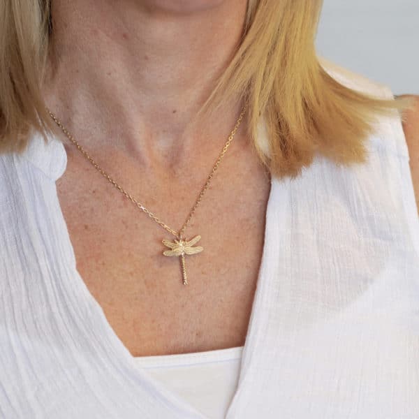 Gold dragonfly necklace worn