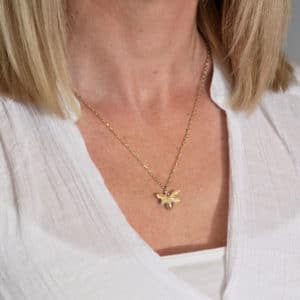 Gold bee necklace worn