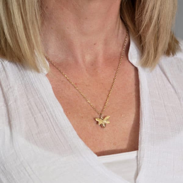 Gold bee necklace worn