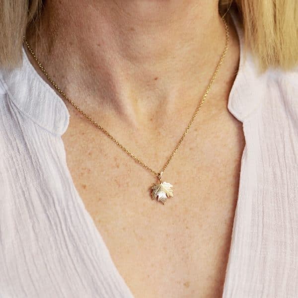 Gold maple leaf necklace worn