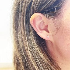 Gold star earrings worn